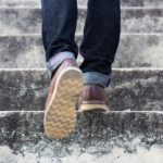 Feet walking up outdoor stairs.