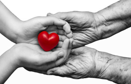 Young and old hands holding a heart