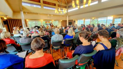 Photo take from the back of the room showing the large number of people attending a Sunday service.