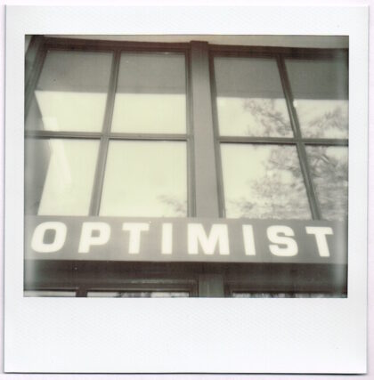large windows with the word Optimist written below