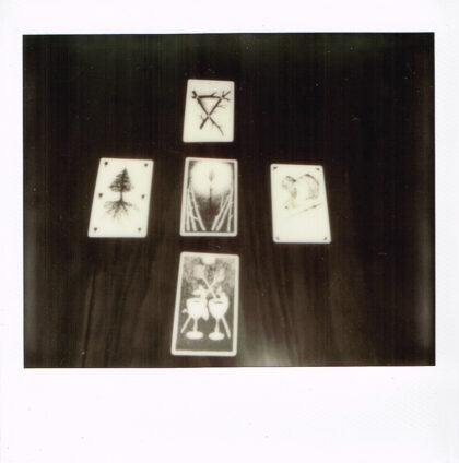black and white photo of tarot cards on a desk