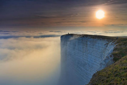 clouds surrounding a cliff