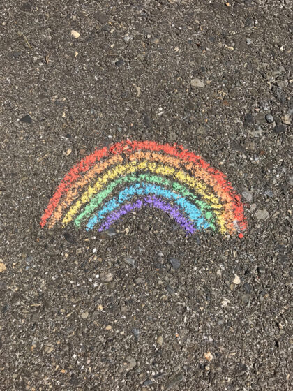 Rainbow logo on rocky ground
