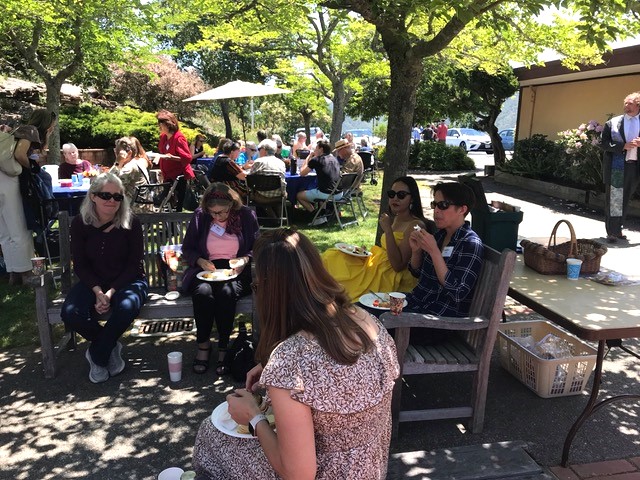 Crowd of people eating in the shade.