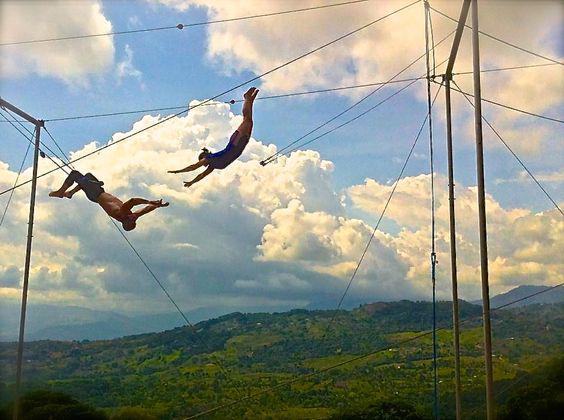 Trapeze artists in mid-transfer.
