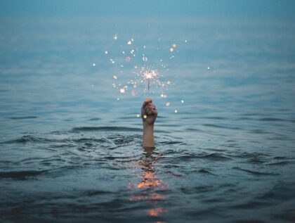 Hand rises out of water holding a sparkler